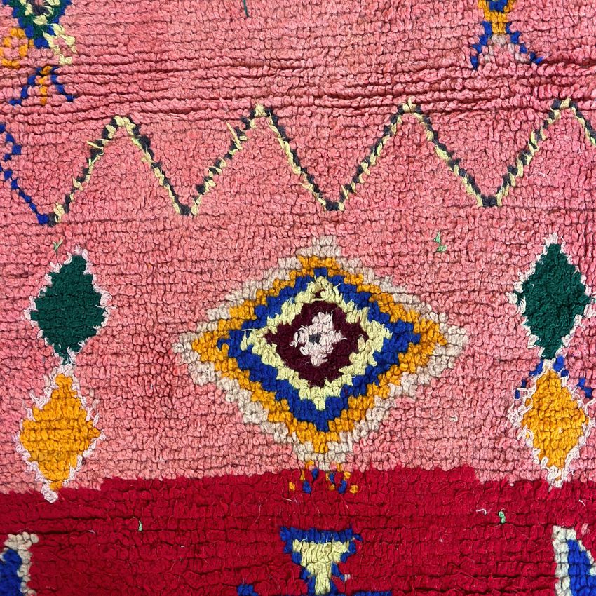 This handwoven Moroccan runner rug with bold red, yellow, and pink hues, featuring geometric Berber motifs is Perfect for boho, modern, contemporary or eclectic interiors. The motifs include diamond (symbolizing protection), zig zag mountain lines, and hourglass shaped butterflies