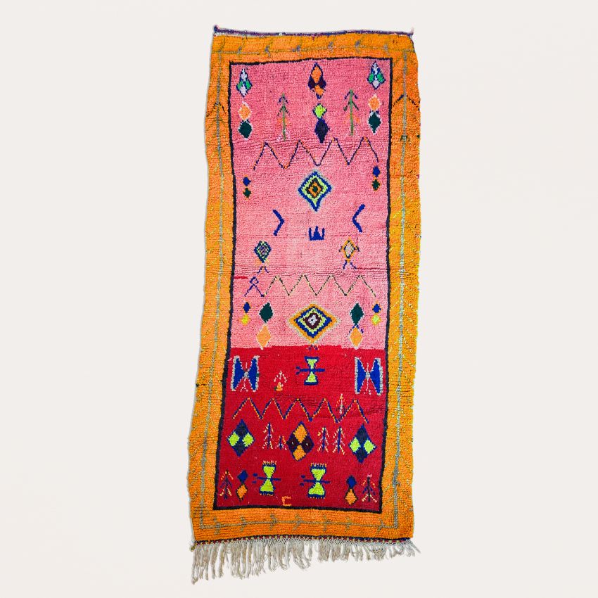 This handwoven Moroccan runner rug with bold red, yellow, and pink hues, featuring geometric Berber motifs is Perfect for boho, modern, contemporary or eclectic interiors. The motifs include diamond (symbolizing protection), zig zag mountain lines, and hourglass shaped butterflies
