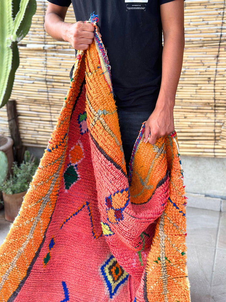 This handwoven Moroccan runner rug with bold red, yellow, and pink hues, featuring geometric Berber motifs is Perfect for boho, modern, contemporary or eclectic interiors. The motifs include diamond (symbolizing protection), zig zag mountain lines, and hourglass shaped butterflies